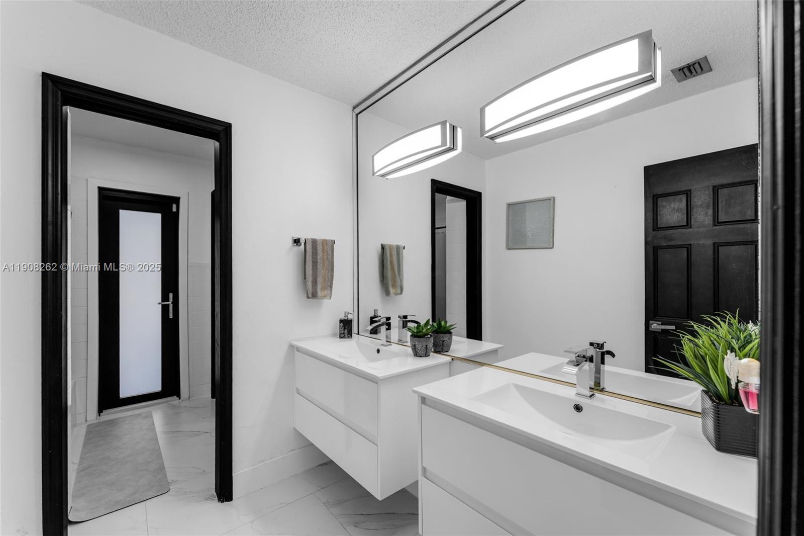 551 Southwest 127th Avenue Miami, FL 33184 - Photo 16 of 47 a bathroom with 2 sink and a mirror