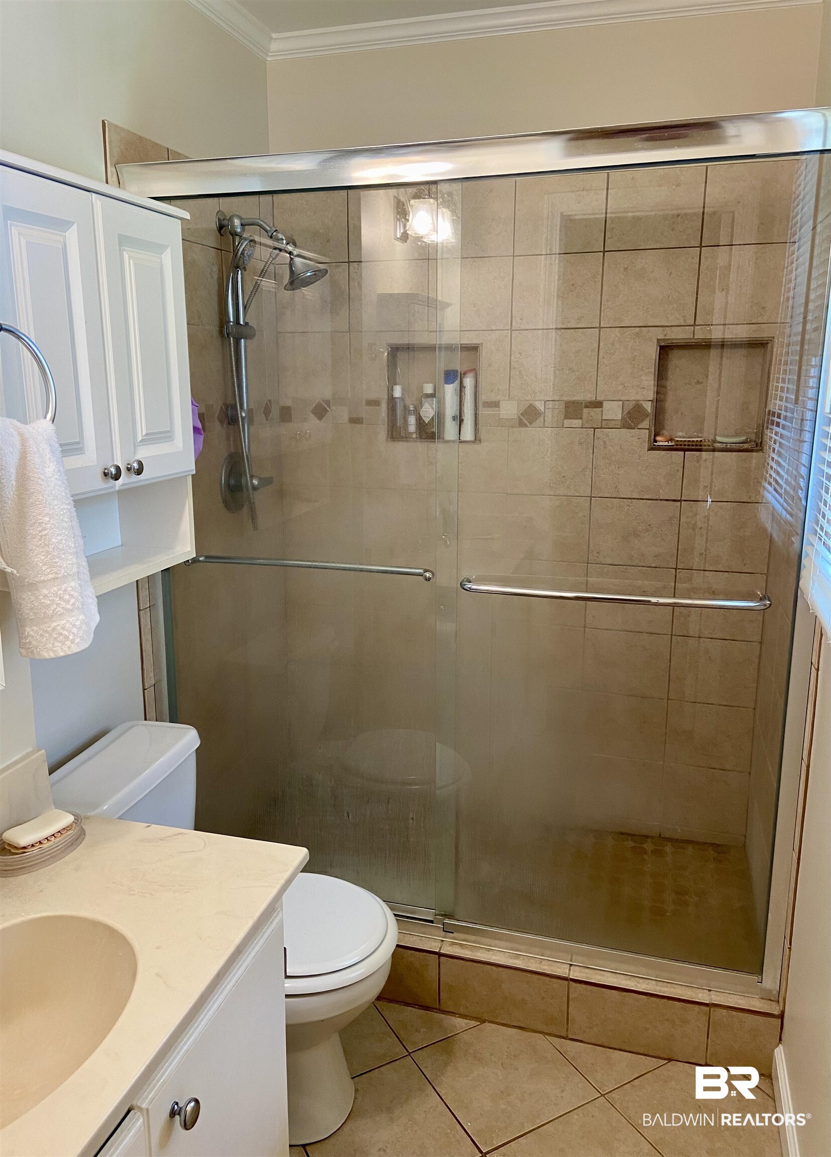 102 Ashley Street Evergreen, AL 36401 - Photo 14 of 26 Bathroom featuring tile patterned flooring, walk in shower, crown molding, toilet, and vanity