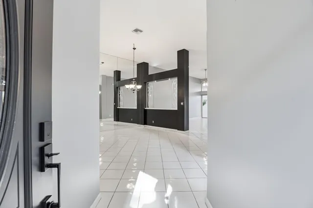 a view of a livingroom with a chandelier fan and windows