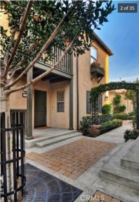 a front view of a house with a yard and potted plants