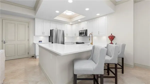 a kitchen with a table chairs refrigerator and microwave