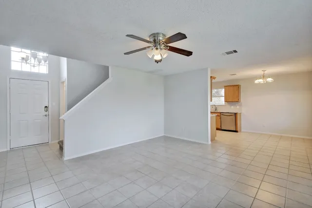 a view of a livingroom with a ceiling fan & window