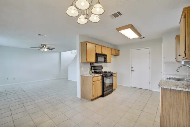 a kitchen with granite countertop a stove a sink and a refrigerator