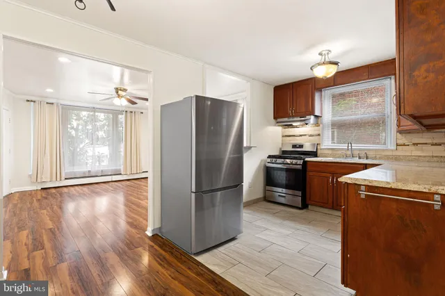 a kitchen with stainless steel appliances granite countertop a refrigerator a sink a stove and oven