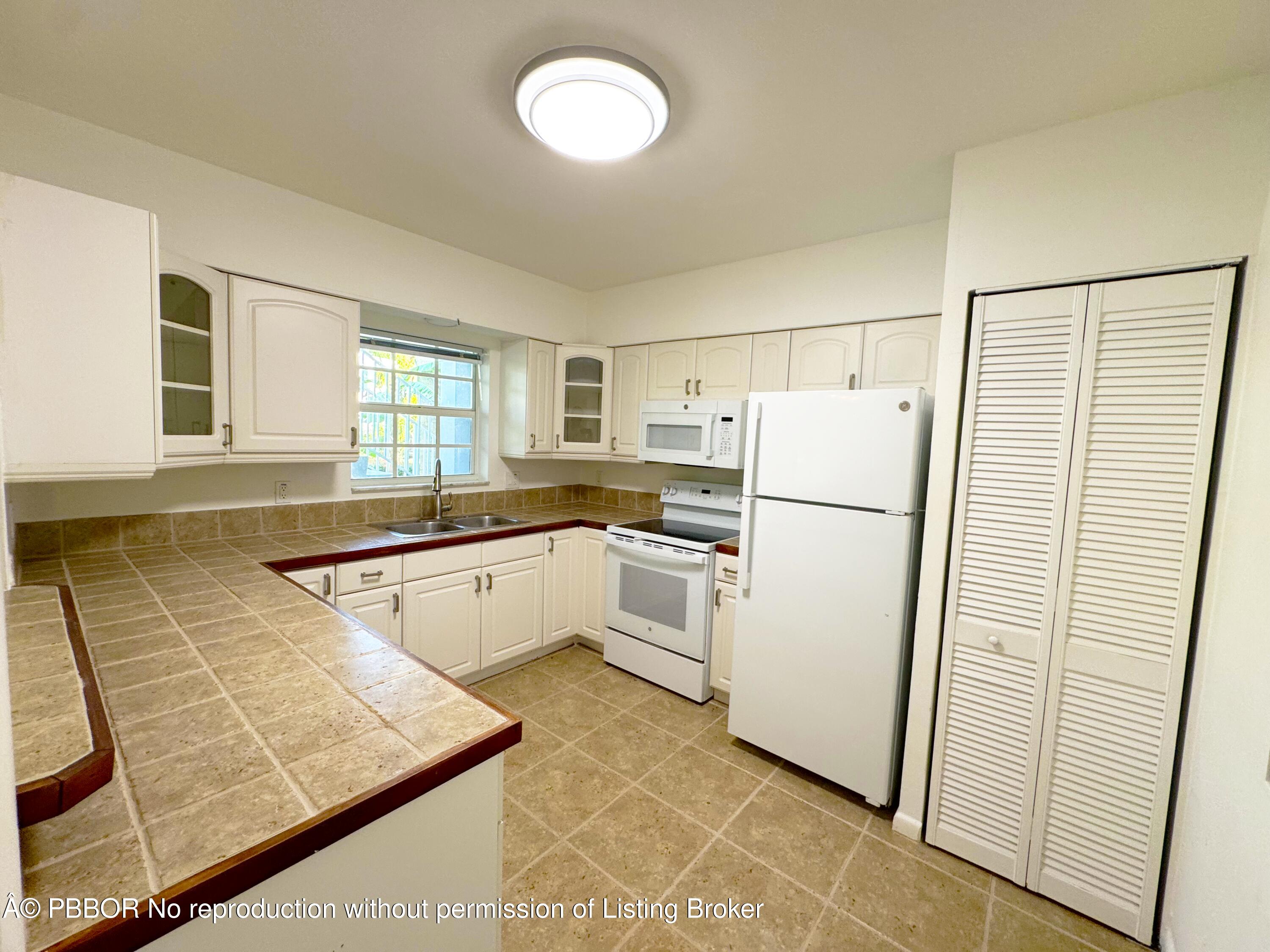 234 Oleander Avenue, Unit 2 Palm Beach, FL 33480 - Photo 6 of 18 a kitchen with white cabinets and white appliances