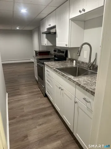 a kitchen with granite countertop white cabinets and white appliances
