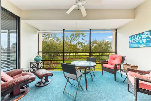 a living room with furniture and a floor to ceiling window
