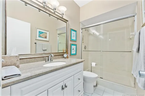 a bathroom with a granite countertop sink toilet a mirror and shower