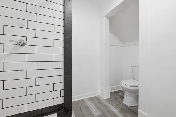 a bathroom with a toilet and a shower