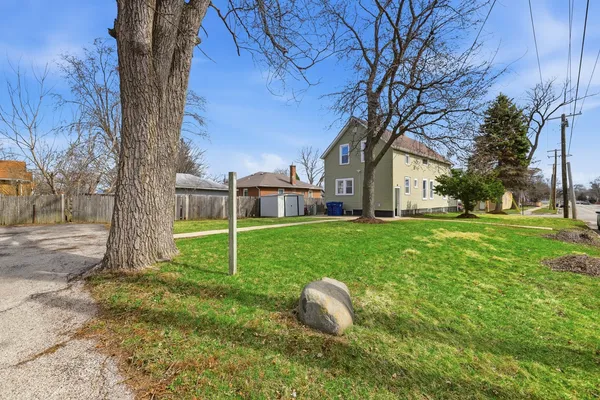 a view of a house with backyard and a tree