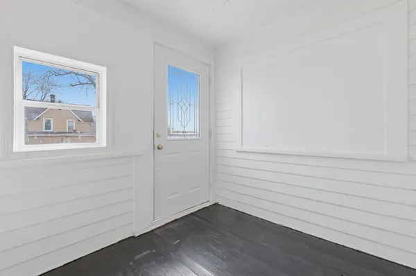 a view of an empty room with wooden floor and closet