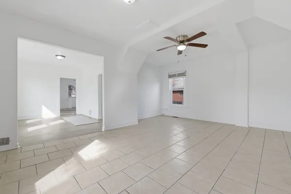 an empty room with fan and windows