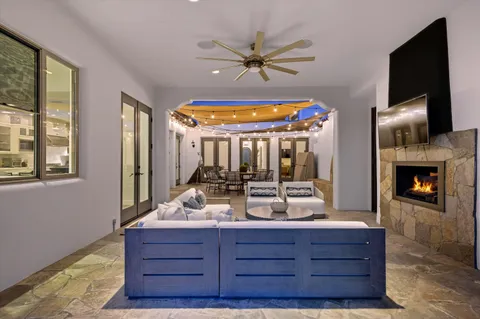a living room with furniture a chandelier and wooden floor