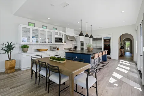 a kitchen with stainless steel appliances granite countertop a sink a stove and a wooden floors