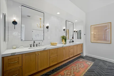 a bathroom with a bathtub a sink and a large mirror