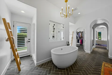 a spacious bedroom with a bed and a chandelier