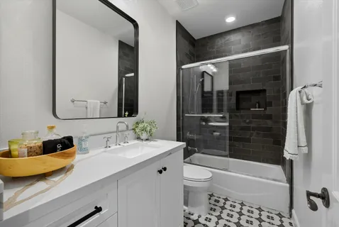 a bathroom with a granite countertop sink a toilet and a mirror
