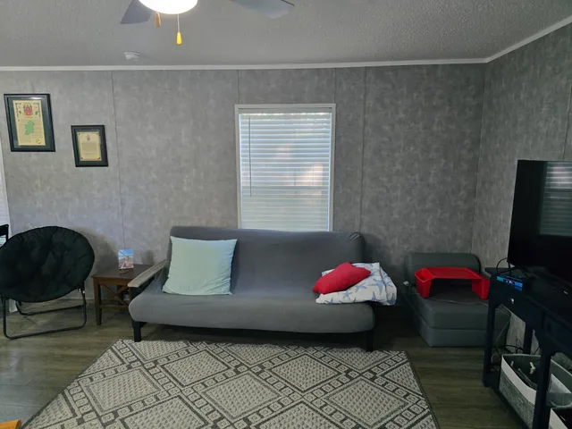 a large bed sitting in a bedroom next to a window with a chair