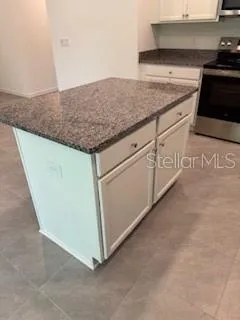 a kitchen with granite countertop white cabinets and white appliances