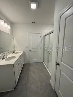 a bathroom with a double vanity sink and mirror