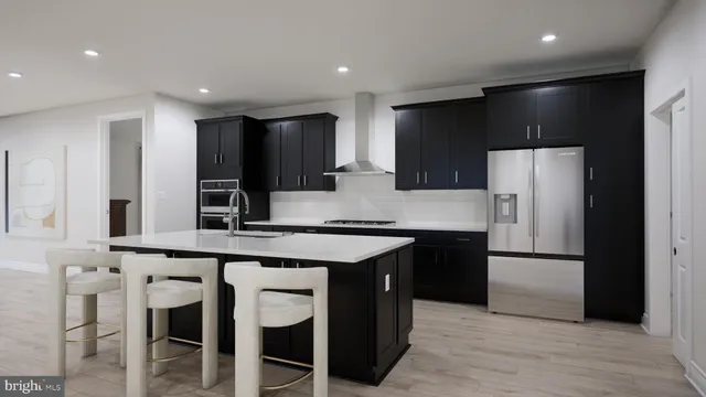 a kitchen with stainless steel appliances a refrigerator and a stove top oven with wooden floor