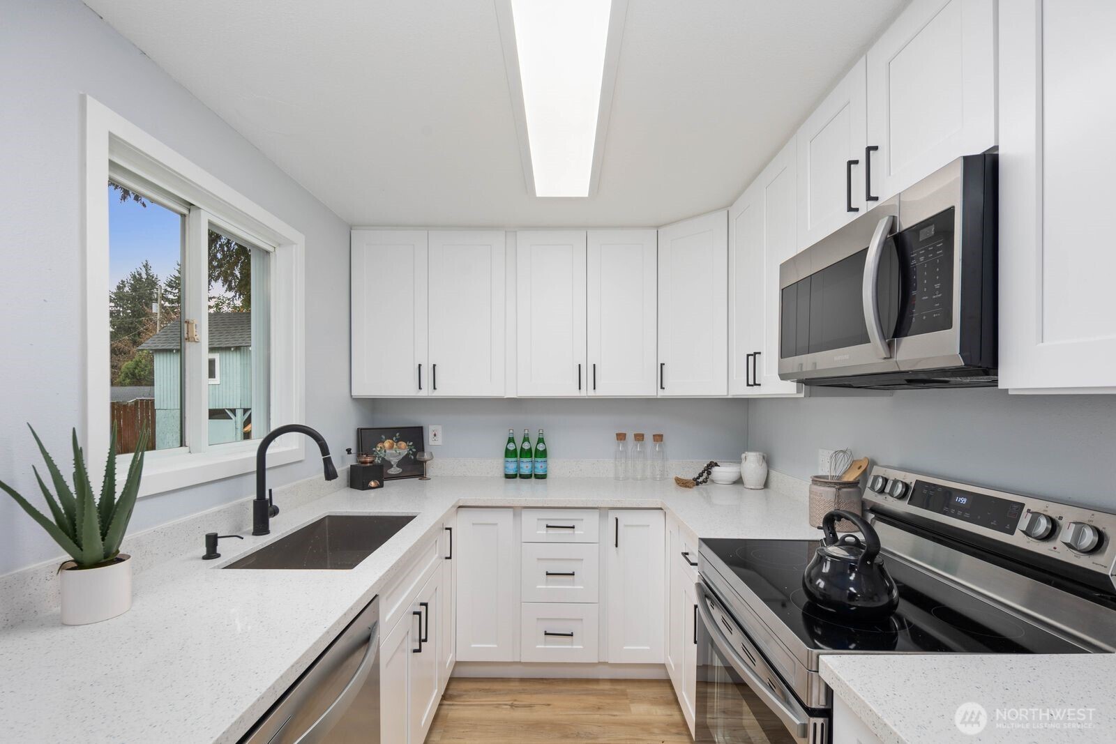 505 Southwest 305th Street Federal Way, WA 98023 - Photo 12 of 38 a kitchen with stainless steel appliances a sink a stove cabinets and a window