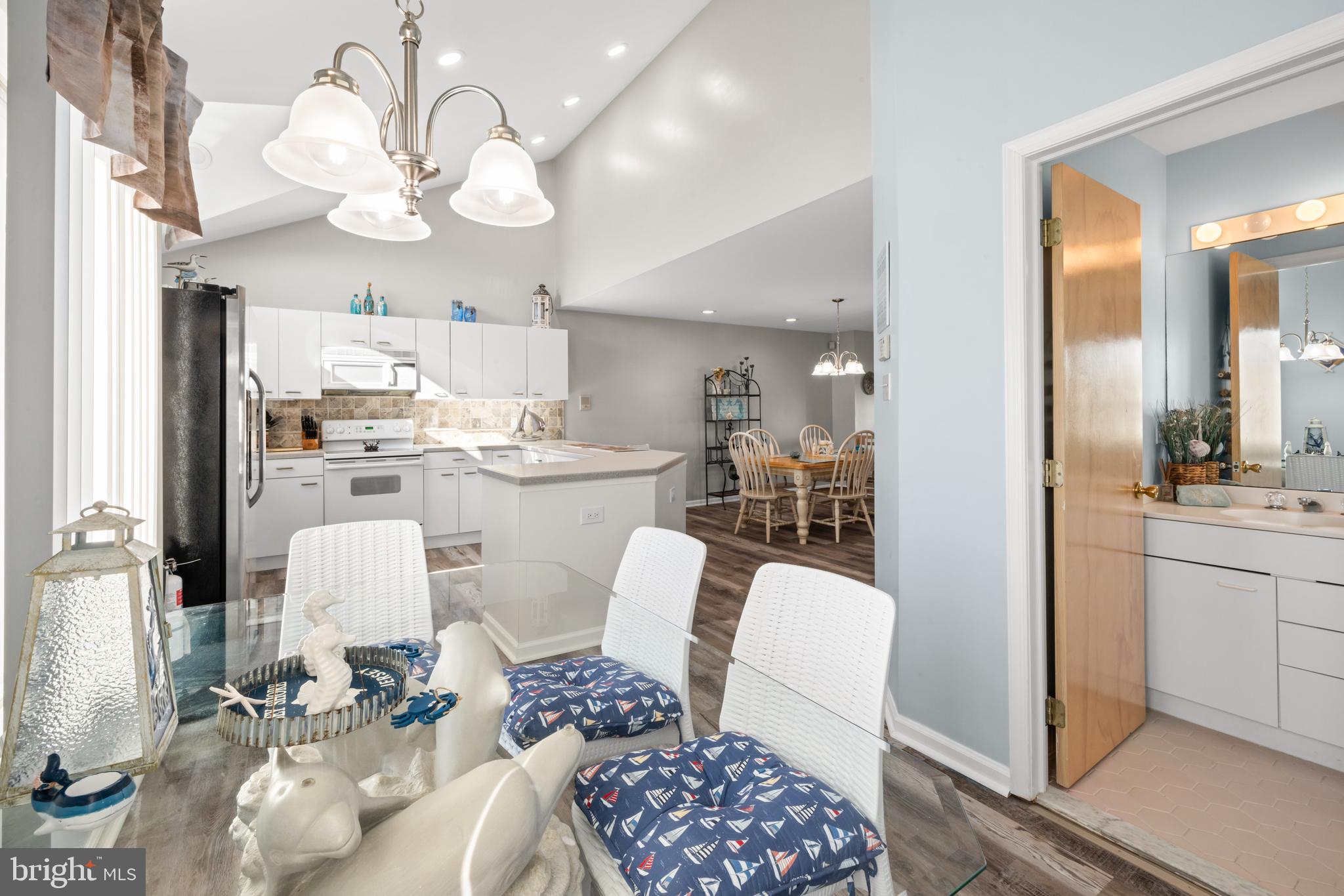 313 Gull Cove Brigantine, NJ 08203 - Photo 17 of 34 a kitchen with a dining table chairs and chandelier