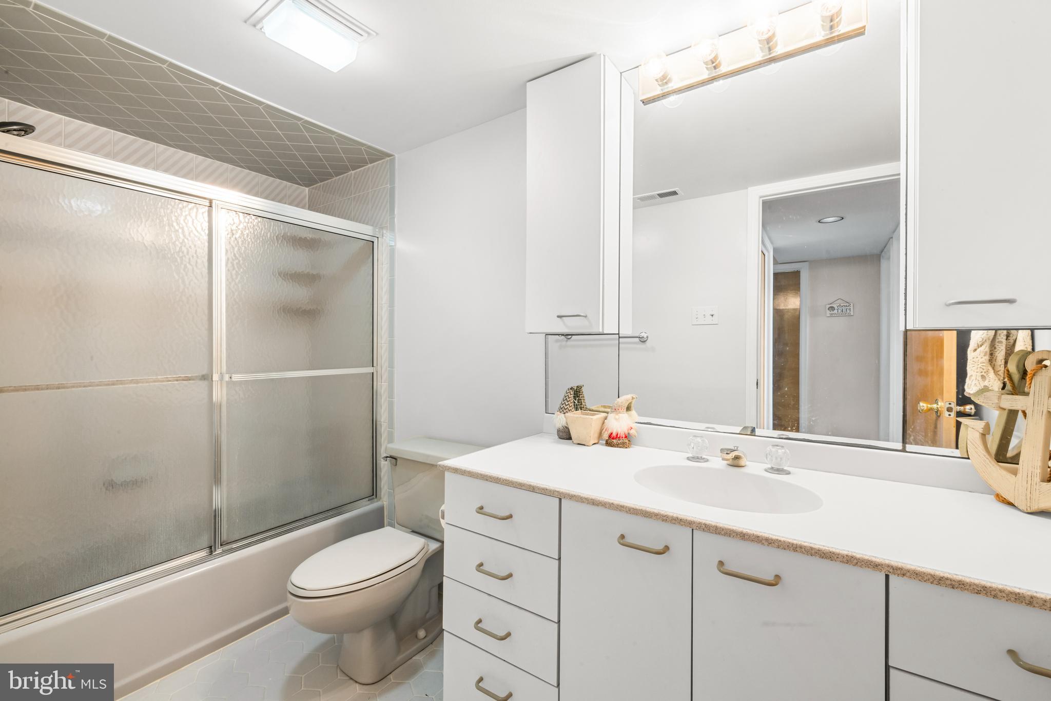 313 Gull Cove Brigantine, NJ 08203 - Photo 8 of 34 a bathroom with a sink a toilet a mirror and shower