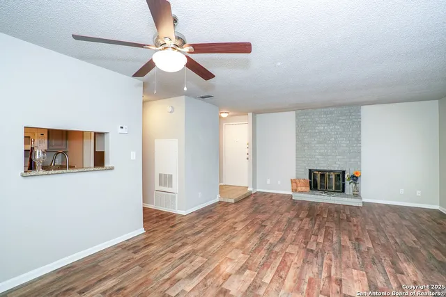 a view of a livingroom with wooden floor and a ceiling fan