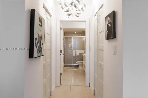 a view of a hallway with wooden floor and a bathroom