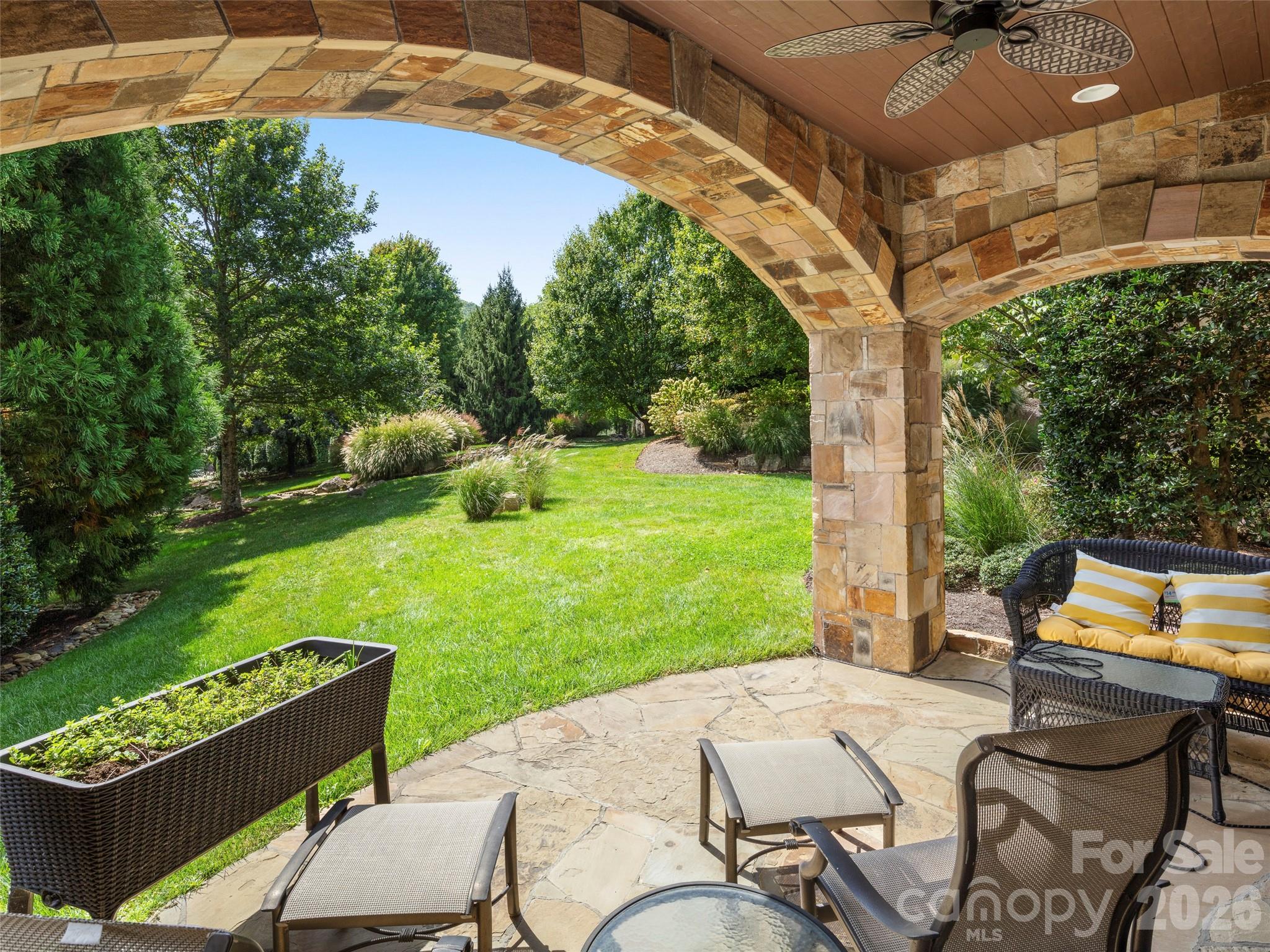 4 Windelsham Way Arden, NC 28704 - Photo 36 of 46 a view of a patio with table and chairs potted plants with large tree