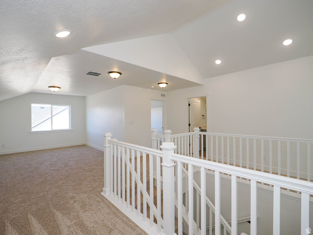 3938 North Wood Road Eagle Mountain, UT 84005 - Photo 33 of 55 Hall with carpet floors, an upstairs landing, a textured ceiling, and recessed lighting