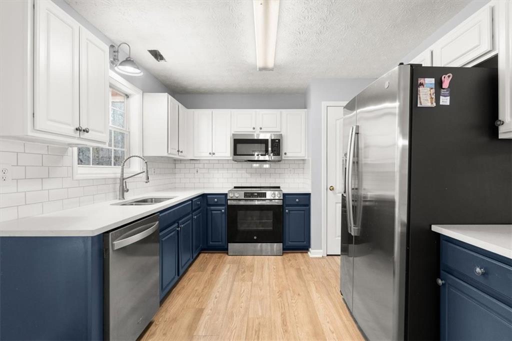 1022 Miss Amber Way Locust Grove, GA 30248 - Photo 11 of 43 a kitchen with stainless steel appliances a refrigerator sink and microwave