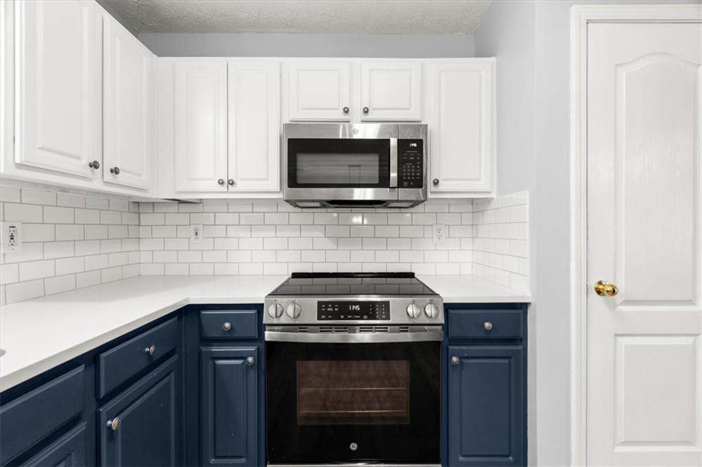 1022 Miss Amber Way Locust Grove, GA 30248 - Photo 12 of 43 a kitchen with stainless steel appliances a stove and a microwave