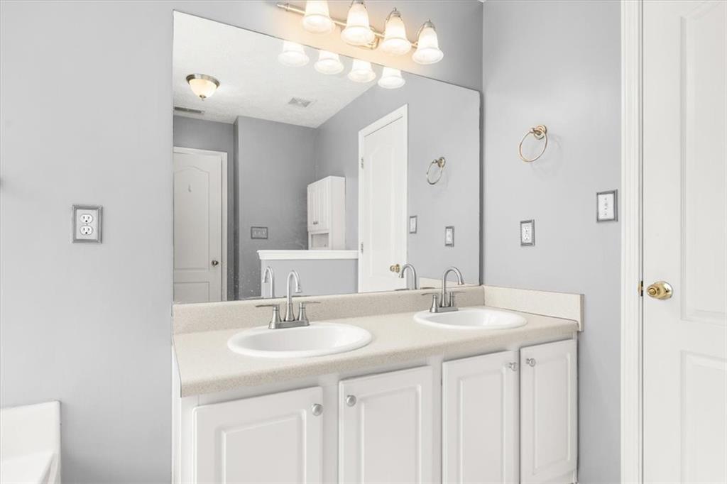 1022 Miss Amber Way Locust Grove, GA 30248 - Photo 19 of 43 a bathroom with a sink double vanity and a mirror
