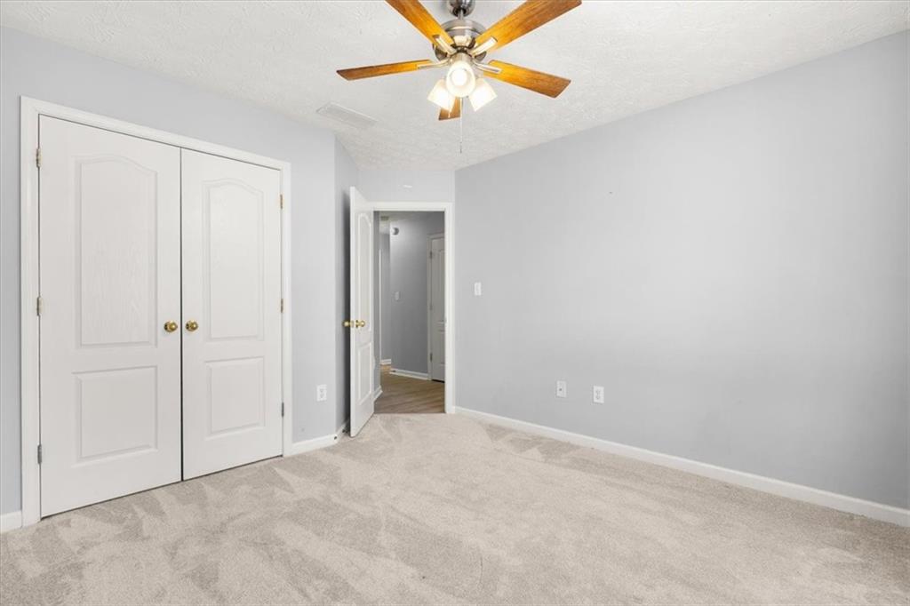 1022 Miss Amber Way Locust Grove, GA 30248 - Photo 23 of 43 an empty room with closet and a chandelier fan