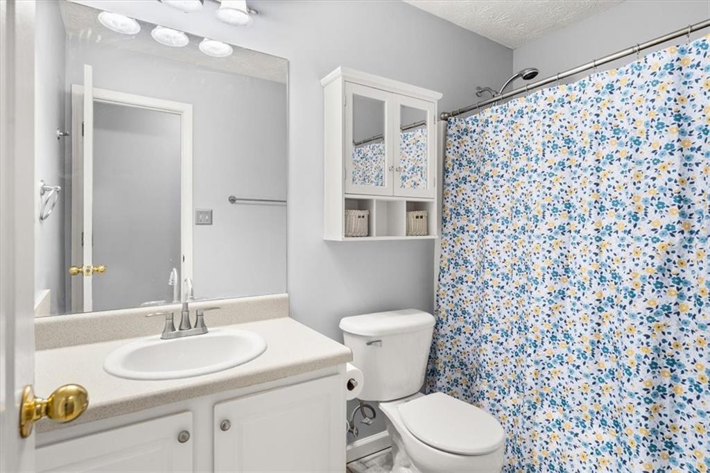 1022 Miss Amber Way Locust Grove, GA 30248 - Photo 24 of 43 a bathroom with a granite countertop sink a toilet and a mirror