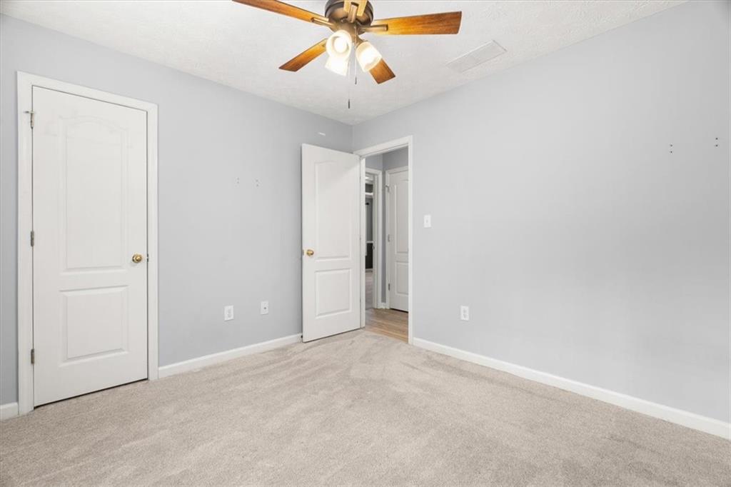 1022 Miss Amber Way Locust Grove, GA 30248 - Photo 26 of 43 an empty room with closet and chandelier fan