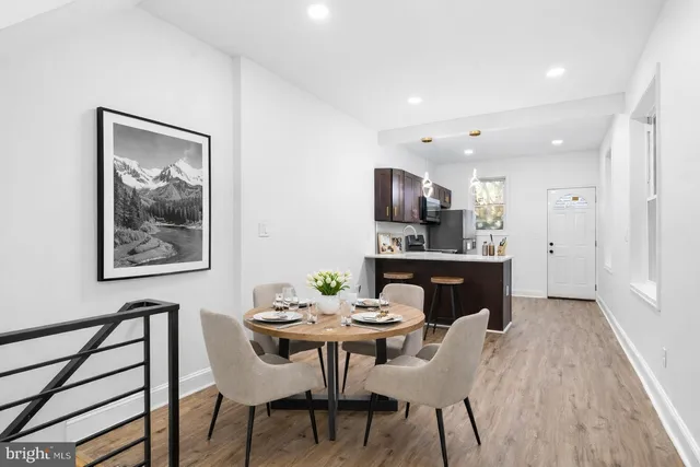 a kitchen with a dining table chairs and refrigerator