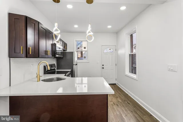 a kitchen with kitchen island a sink appliances and cabinets