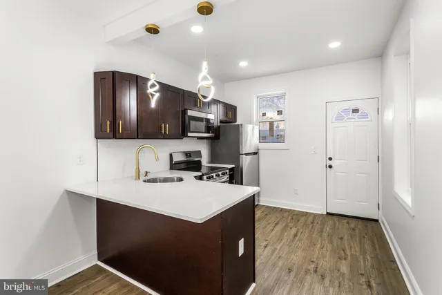 a kitchen with a sink cabinets and wooden floor