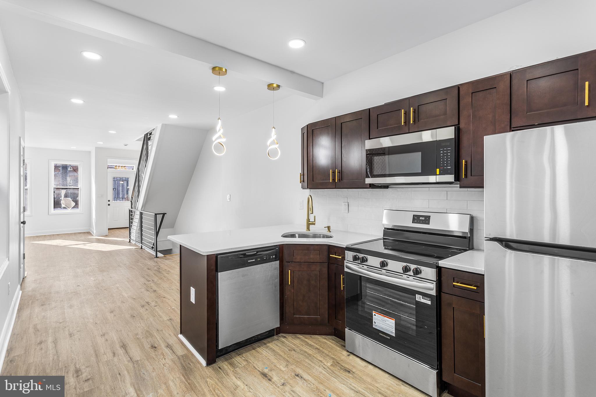 2933 Master Street Philadelphia, PA 19121 - Photo 6 of 28 a kitchen with stainless steel appliances a stove sink microwave and cabinets