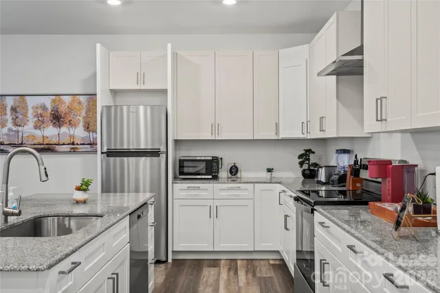 a kitchen with stainless steel appliances granite countertop a sink stove and refrigerator