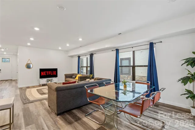 a living room with dining room and wooden floor