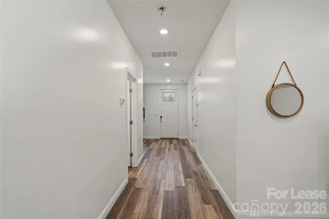 a view of a hallway with wooden floor