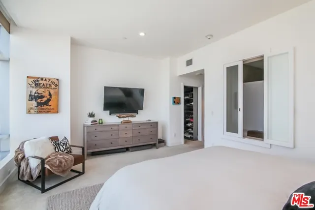 a bedroom with furniture and a flat screen tv