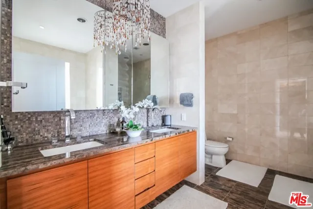 a bathroom with a granite countertop sink mirror vanity and toilet
