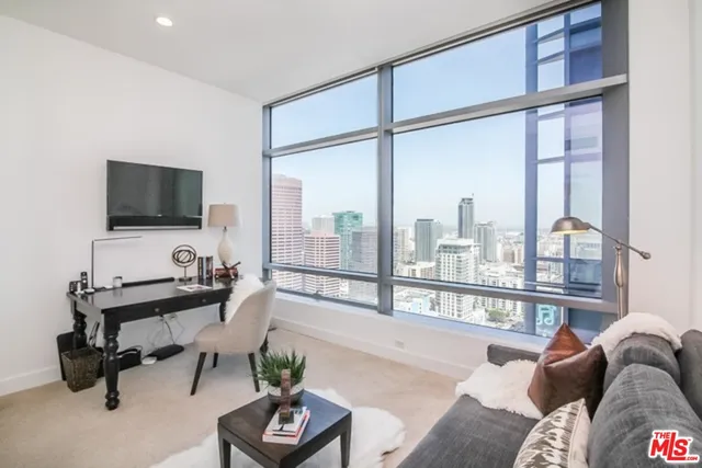 a view of a livingroom with workspace and a large window