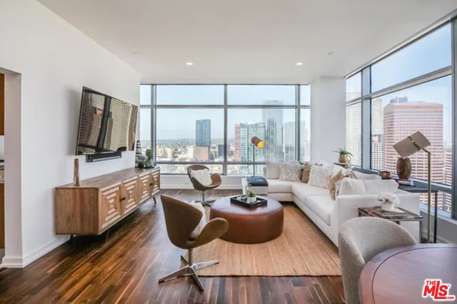 a living room with furniture a flat screen tv and a floor to ceiling window