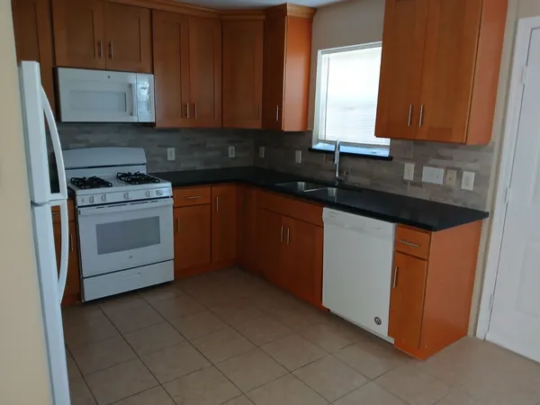 a kitchen with granite countertop cabinets stainless steel appliances and a sink